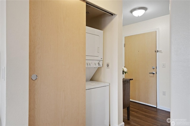 laundry room featuring dark wood-type flooring and stacked washer / drying machine