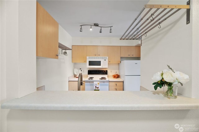 kitchen with light brown cabinets, white appliances, and sink