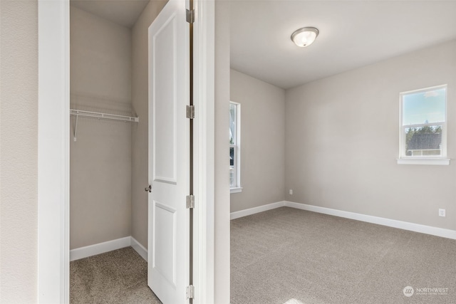 unfurnished bedroom featuring light carpet and a closet