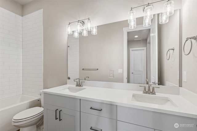 full bathroom with vanity, tiled shower / bath combo, and toilet