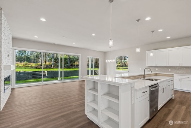 kitchen featuring white cabinets, dark hardwood / wood-style floors, pendant lighting, and an island with sink