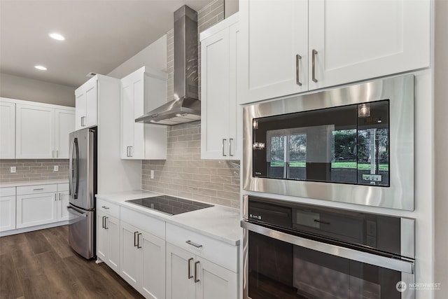 kitchen with white cabinets, decorative backsplash, wall chimney exhaust hood, and stainless steel appliances