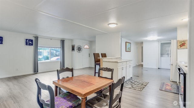 dining space with light hardwood / wood-style floors and washer / clothes dryer