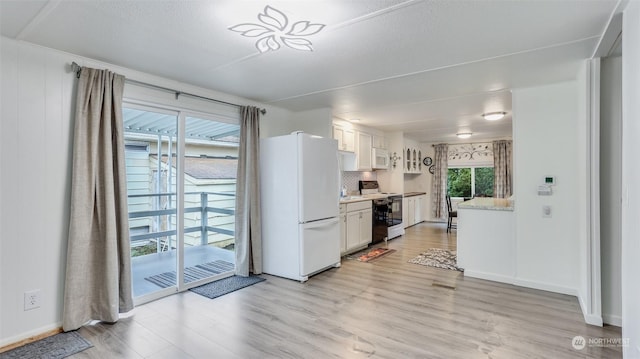 kitchen with decorative backsplash, a textured ceiling, white appliances, light hardwood / wood-style flooring, and white cabinetry