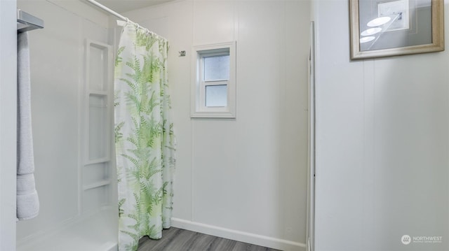 bathroom with a shower with shower curtain and hardwood / wood-style floors