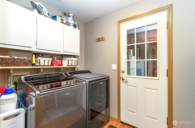 clothes washing area featuring light hardwood / wood-style floors, cabinets, and washing machine and clothes dryer