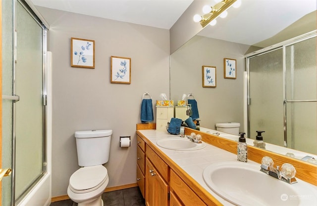 full bathroom with tile patterned floors, shower / bath combination with glass door, vanity, and toilet