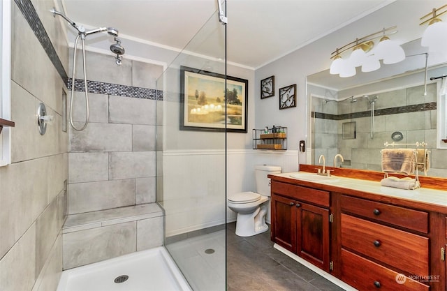 bathroom with walk in shower, crown molding, vanity, and toilet