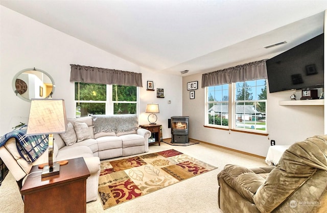 living room featuring carpet flooring, a wood stove, and lofted ceiling