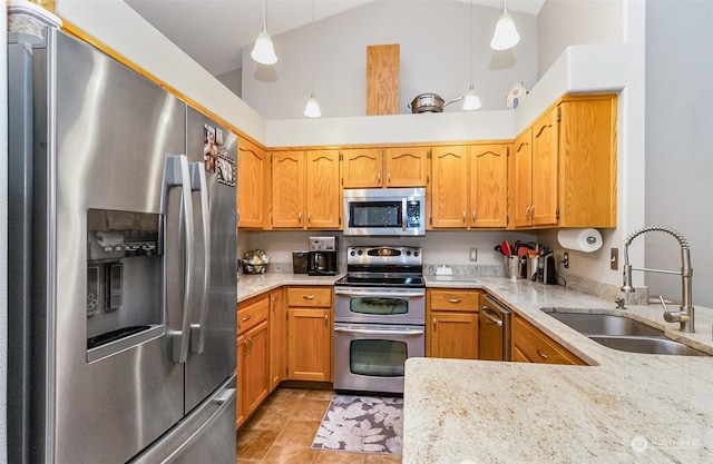 kitchen with pendant lighting, lofted ceiling, sink, kitchen peninsula, and stainless steel appliances