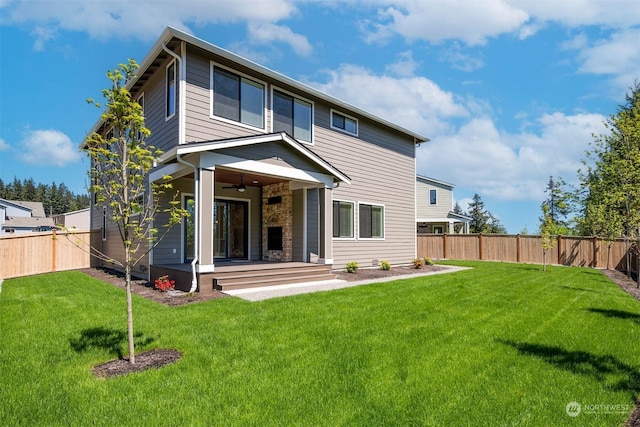 back of house featuring ceiling fan and a lawn