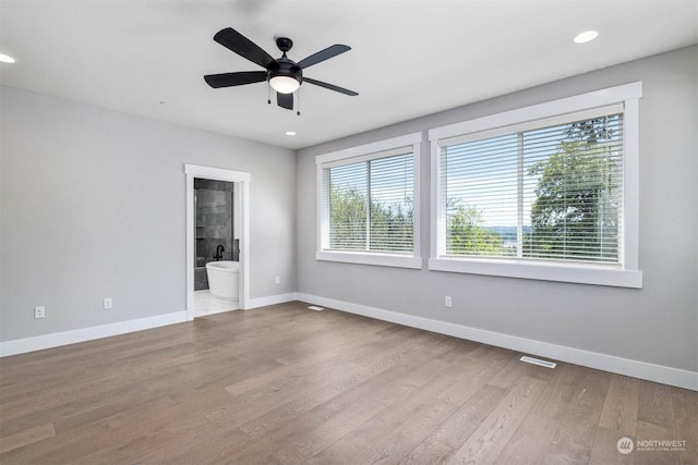 empty room with ceiling fan, light hardwood / wood-style floors, and a wealth of natural light