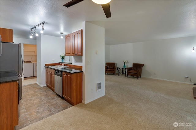 kitchen featuring light carpet, sink, ceiling fan, independent washer and dryer, and stainless steel appliances