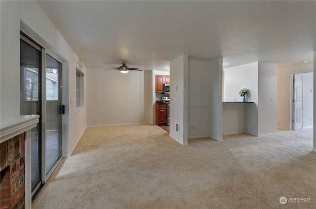 unfurnished living room featuring light carpet and ceiling fan