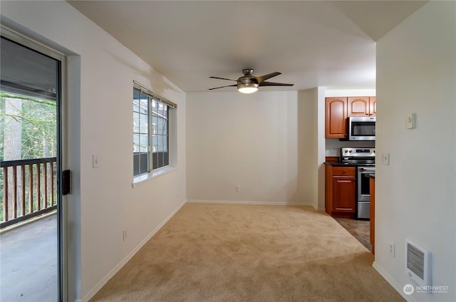 interior space with ceiling fan, carpet floors, and appliances with stainless steel finishes