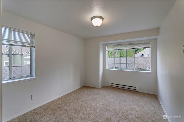 carpeted empty room with baseboard heating