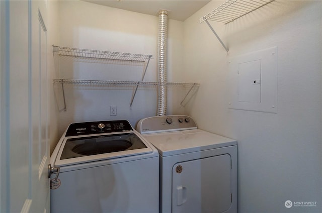 clothes washing area with washer and clothes dryer and electric panel