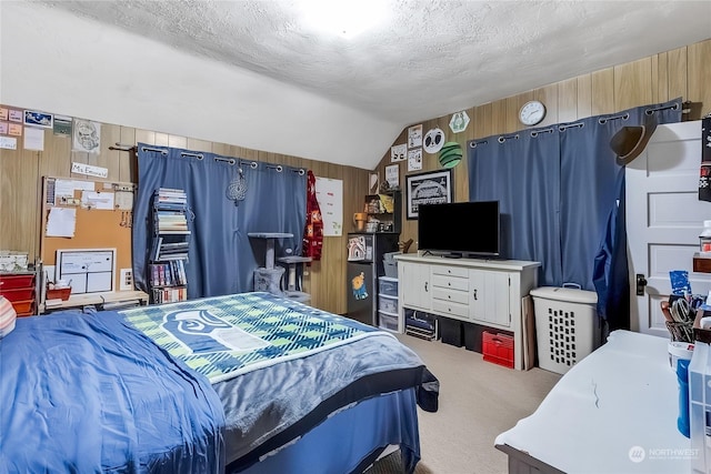 carpeted bedroom with a textured ceiling, lofted ceiling, and wood walls