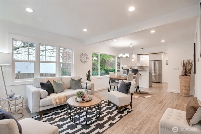 living room featuring a notable chandelier and light hardwood / wood-style flooring