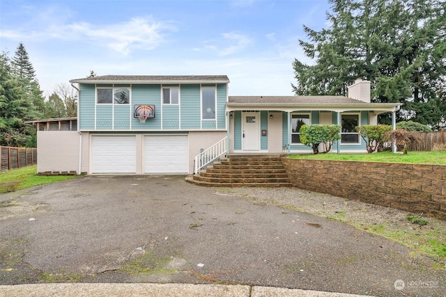 tri-level home featuring covered porch and a garage