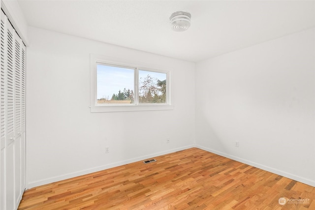 unfurnished bedroom featuring a closet and light hardwood / wood-style flooring