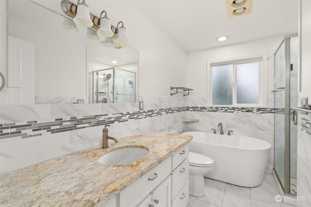 full bathroom featuring vanity, toilet, tile walls, and independent shower and bath