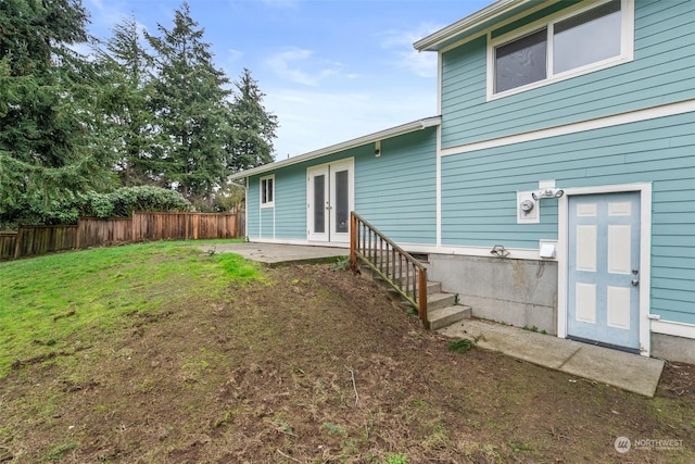 back of property featuring french doors and a lawn