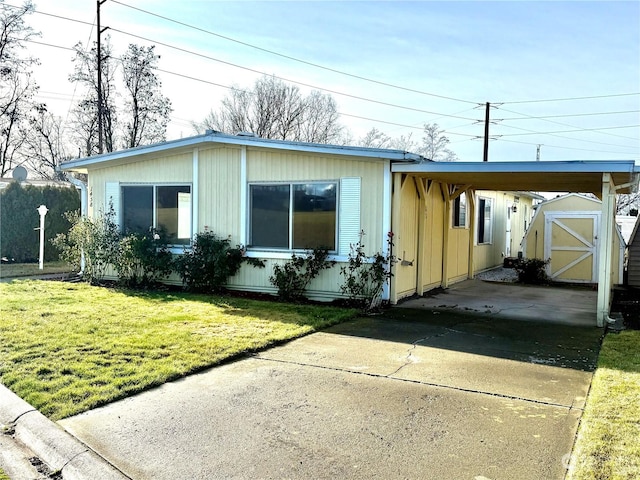 view of front of house with a carport, a storage unit, and a front yard