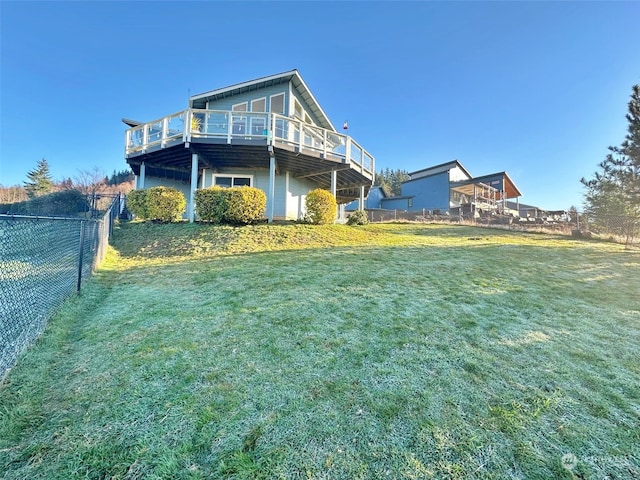 back of property featuring a wooden deck and a lawn