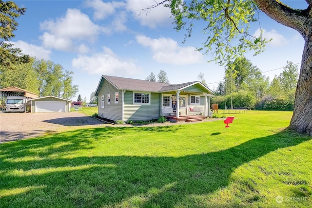 view of front of home featuring a front lawn, covered porch, an outdoor structure, and a garage