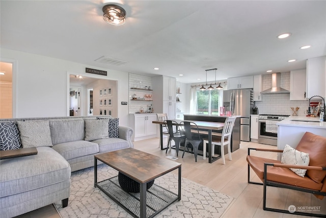 living room with light hardwood / wood-style floors and sink