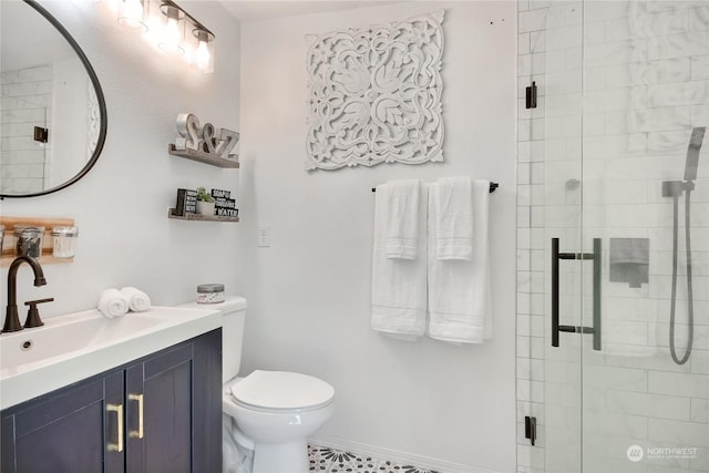 bathroom with a shower with door, vanity, and toilet