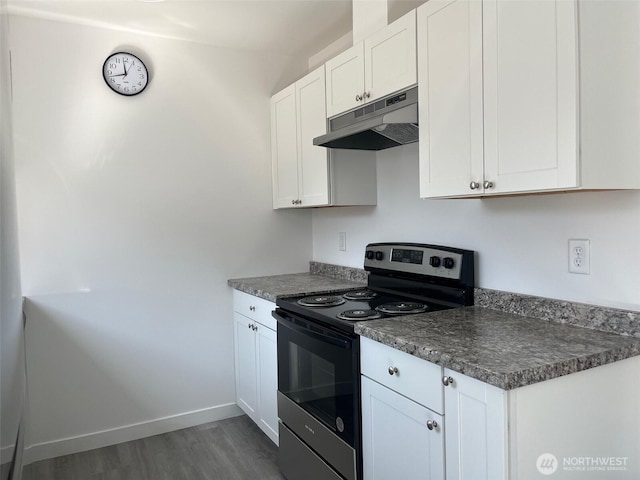 1306 Melbourne Ct, Westport, WA 98595 - kitchen featuring under cabinet range hood, white cabinetry, dark wood-style floors, range with electric cooktop, and dark countertops
