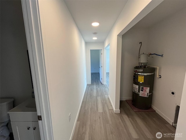 1306 Melbourne Ct, Westport, WA 98595 - corridor with baseboards, light wood-style floors, and secured water heater