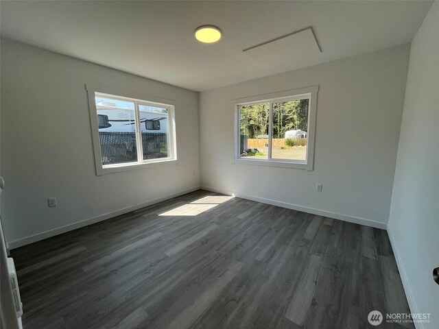 1306 Melbourne Ct, Westport, WA 98595 - spare room featuring dark wood-type flooring, baseboards, and a healthy amount of sunlight