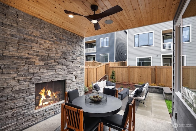 view of patio / terrace with a ceiling fan, a fenced backyard, and an outdoor living space with a fireplace