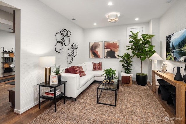 living area with baseboards, wood finished floors, and recessed lighting