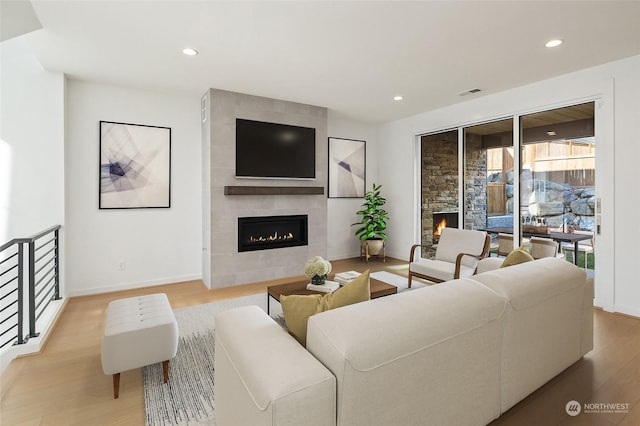 living room featuring light wood-type flooring and a fireplace