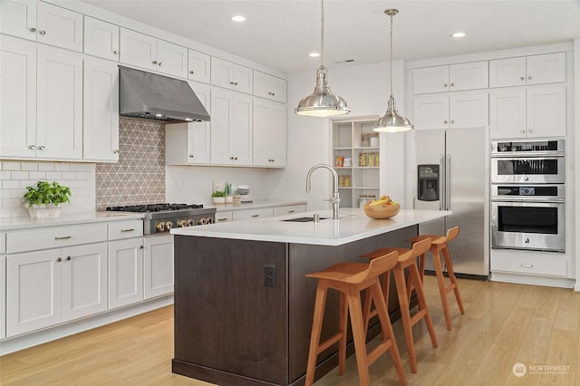 kitchen featuring white cabinetry, sink, an island with sink, and stainless steel appliances