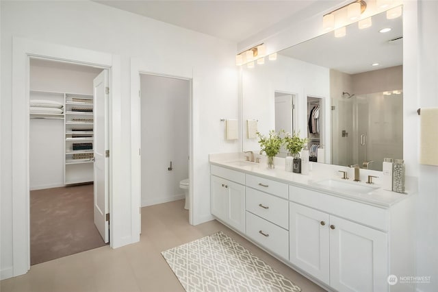 bathroom with toilet, an enclosed shower, and vanity