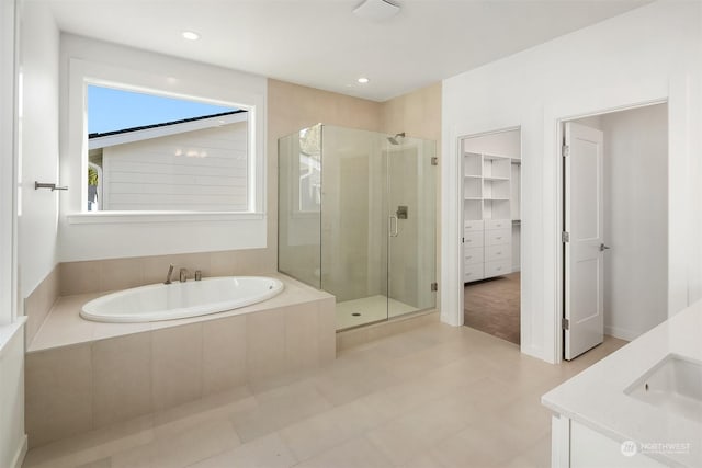 bathroom featuring separate shower and tub and vanity