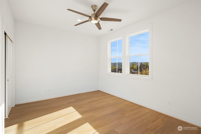 unfurnished bedroom with ceiling fan, light wood-type flooring, and a closet