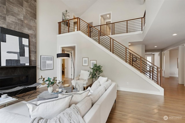 living room with wood-type flooring and a towering ceiling