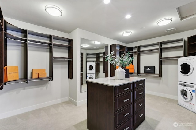 spacious closet featuring light carpet and stacked washer / dryer