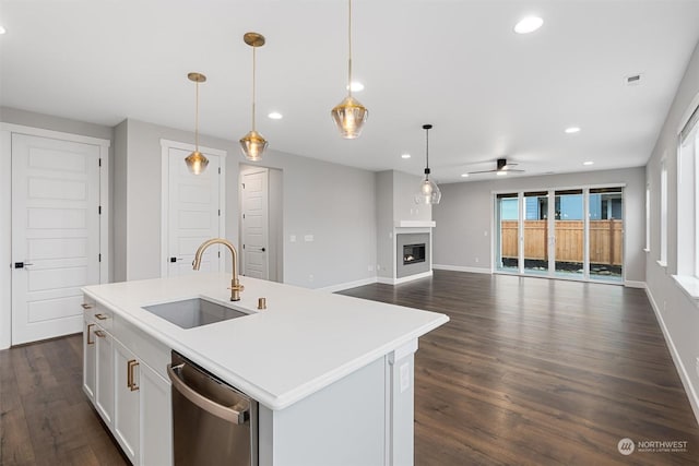 kitchen featuring pendant lighting, a kitchen island with sink, sink, and stainless steel dishwasher