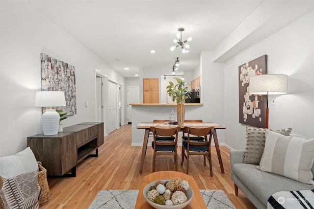 dining area featuring light hardwood / wood-style flooring and an inviting chandelier