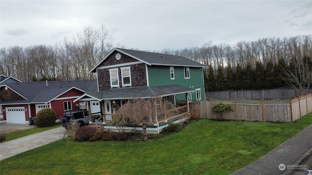 view of front of property featuring a porch, a front lawn, and a garage