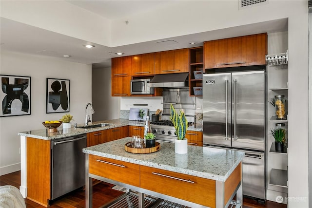 kitchen with a center island, sink, built in appliances, dark hardwood / wood-style flooring, and kitchen peninsula