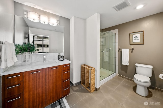 bathroom with tile patterned floors, vanity, toilet, and a shower with shower door