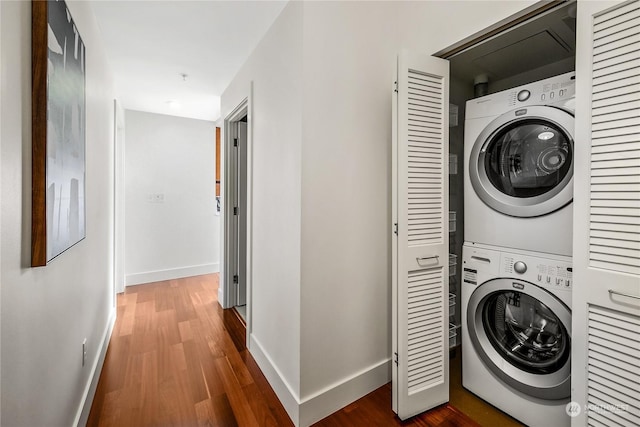 laundry area with stacked washing maching and dryer and hardwood / wood-style flooring